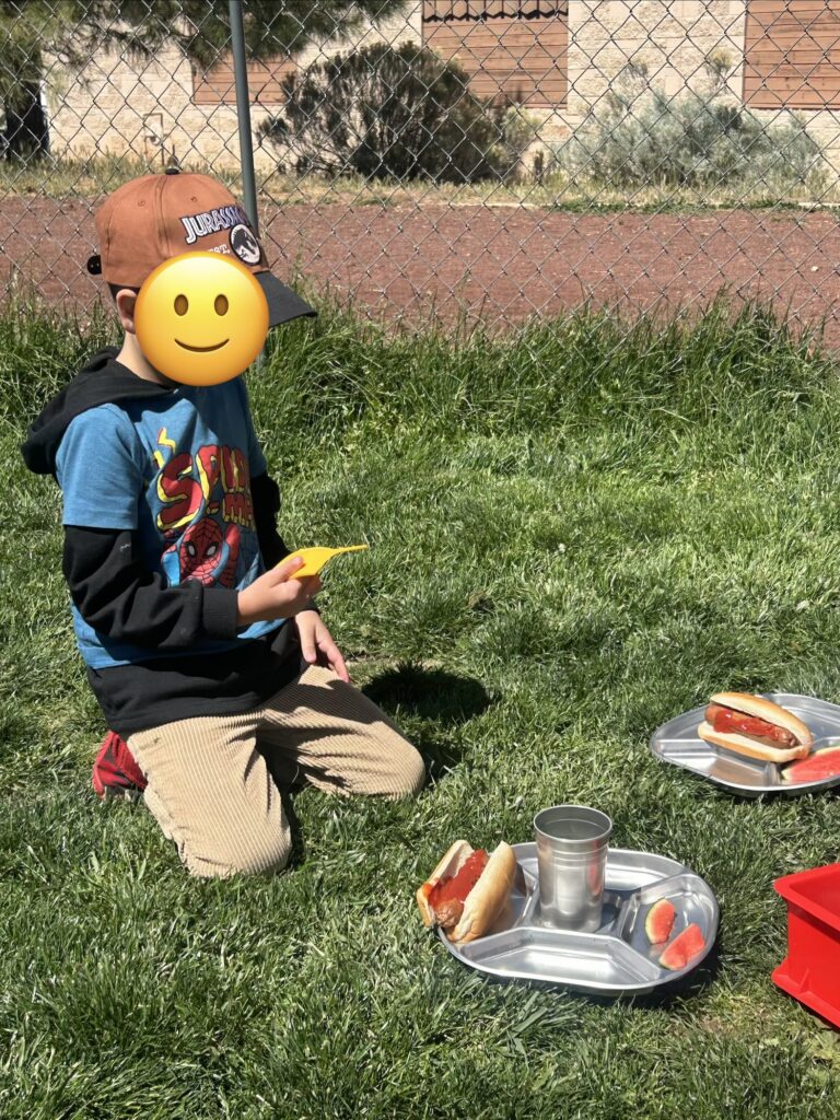 Student at school picnic using tray and cup